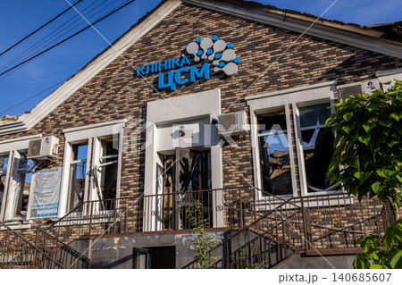Bila Tserkva, Kyiv region, Ukraine - 09.06.2025: Facade of modern brick medical clinic building damaged by explosion with shattered window glass broken door and ruined roof under blue sky Bila Tserkva, Kyiv region, Ukraine - 09.06.2025: Facade of modern brick medical clinic building damaged by explosion with shattered window glass broken door and ruined roof under blue sky 140685607