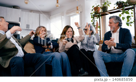 Seniors friends enjoying video game entertainment at home Seniors friends enjoying video game entertainment at home 140685850