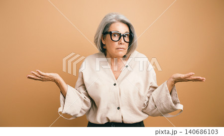 Senior woman shrugging with confused expression 140686103
