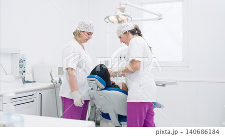 Dentist and dental assistant examining patient in clinic Dentist and dental assistant examining patient in clinic 140686184