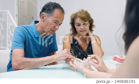Couple consulting dentist regarding dental prosthesis options 140686191