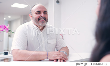 Man talking to reception in dental clinic 140686195
