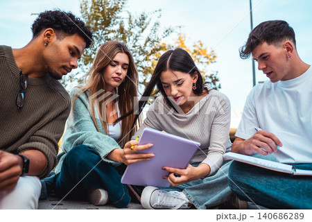 Diverse students collaborating on study group outdoors Diverse students collaborating on study group outdoors 140686289