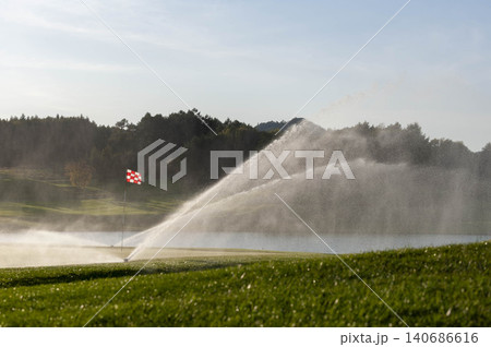 ゴルフコースのグリーンで芝生に水を撒くスプリンクラーの風景 ゴルフコースのグリーンで芝生に水を撒くスプリンクラーの風景 140686616