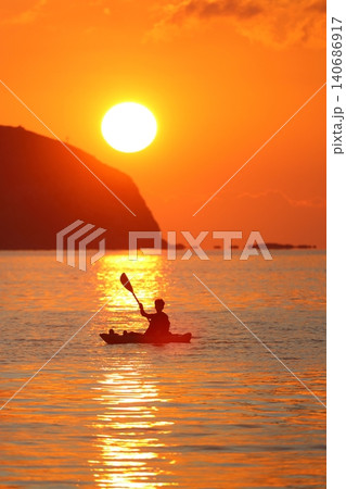 silhouette of a man in a canoe with a sunset background silhouette of a man in a canoe with a sunset background 140686917
