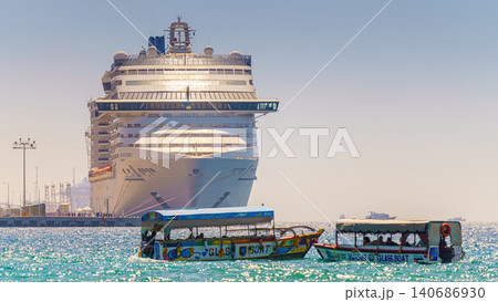 Aqaba, Jordan - Mar 13 2023, a panoramic view of MSC Splendida cruise ship in the marina, with two little boats on foreground, at daytime, Aqaba, Jordan 140686930