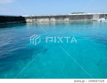 沖縄の港に広がる透明なターコイズブルーの海と防波堤 沖縄の港に広がる透明なターコイズブルーの海と防波堤 140687326