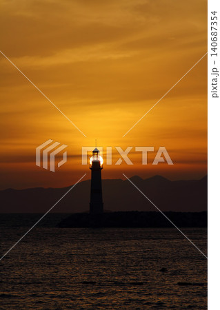 Seascape at sunshine. Lighthouse and sailings on the coast. Seaside town of Turgutreis and spectacular sunshine Seascape at sunshine. Lighthouse and sailings on the coast. Seaside town of Turgutreis and spectacular sunshine 140687354