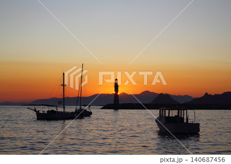 Seascape at sunshine. Lighthouse and sailings on the coast. Seaside town of Turgutreis and spectacular sunshine Seascape at sunshine. Lighthouse and sailings on the coast. Seaside town of Turgutreis and spectacular sunshine 140687456