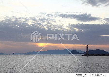 Seascape at sunshine. Lighthouse and sailings on the coast. Seaside town of Turgutreis and spectacular sunshine Seascape at sunshine. Lighthouse and sailings on the coast. Seaside town of Turgutreis and spectacular sunshine 140687477