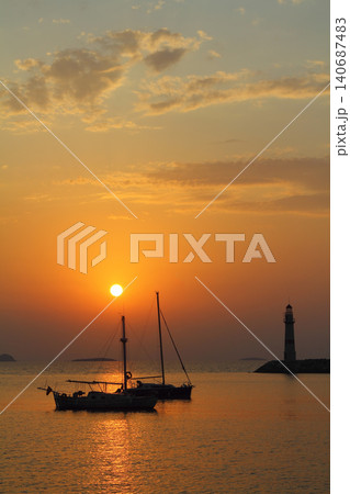 Seascape at sunshine. Lighthouse and sailings on the coast. Seaside town of Turgutreis and spectacular sunshine Seascape at sunshine. Lighthouse and sailings on the coast. Seaside town of Turgutreis and spectacular sunshine 140687483