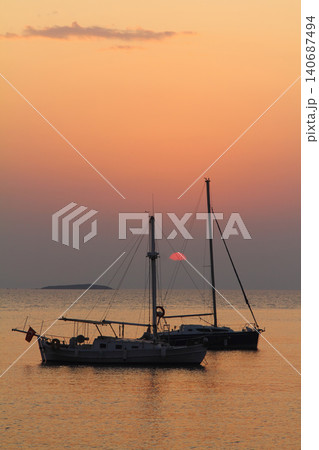 Alone sailboat at sunset. Atmospheric seascape with reflection Alone sailboat at sunset. Atmospheric seascape with reflection 140687494