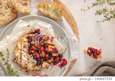 Baked or fried grilled Camembert or brie cheese with berry sauce or jam. Gourmet traditional Breakfast close up. Baked or fried grilled Camembert or brie cheese with berry sauce or jam. Gourmet traditional Breakfast close up. 140687550