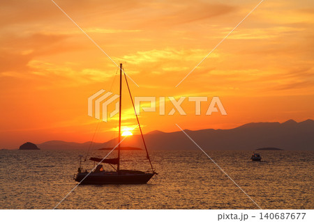 Alone sailboat at sunset. Atmospheric seascape with reflection Alone sailboat at sunset. Atmospheric seascape with reflection 140687677