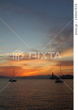 Seascape at sunshine. Lighthouse and sailings on the coast. Seaside town of Turgutreis and spectacular sunshine Seascape at sunshine. Lighthouse and sailings on the coast. Seaside town of Turgutreis and spectacular sunshine 140687679