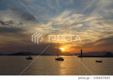 Seascape at sunshine. Lighthouse and sailings on the coast. Seaside town of Turgutreis and spectacular sunshine Seascape at sunshine. Lighthouse and sailings on the coast. Seaside town of Turgutreis and spectacular sunshine 140687685