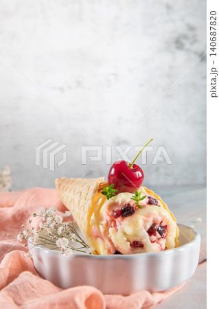 Traditional waffle cones with ice cream and cherry fruits Traditional waffle cones with ice cream and cherry fruits 140687820