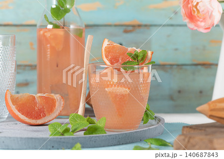 Grapefruit juice with mint in glasses on the table. Refreshing summer cocktail. Grapefruit juice with mint in glasses on the table. Refreshing summer cocktail. 140687843