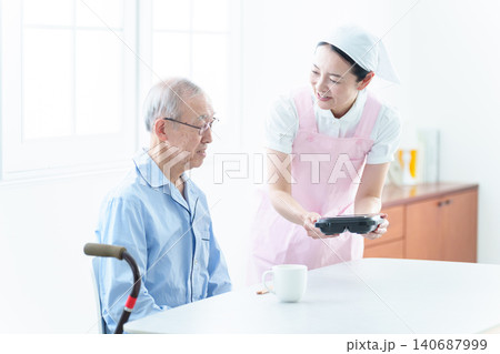 高齢者に配膳をするヘルパー 高齢者に配膳をするヘルパー 140687999