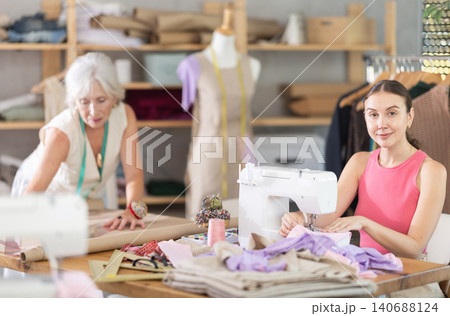 Adult woman seamstress sewing woman assistant drawing pattern 140688124