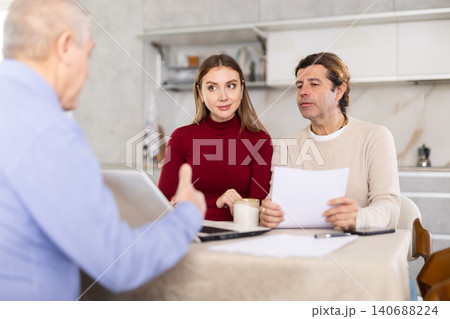 Couple discussing deal with salesman in kitchen Couple discussing deal with salesman in kitchen 140688224