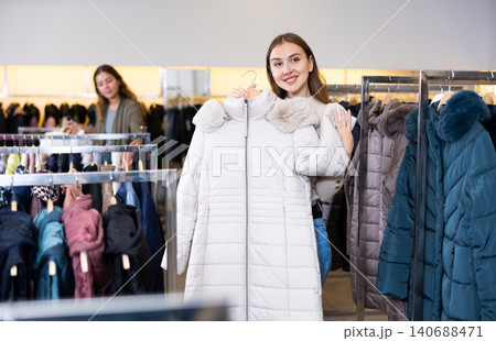 Young woman choosing insulated coat in store 140688471