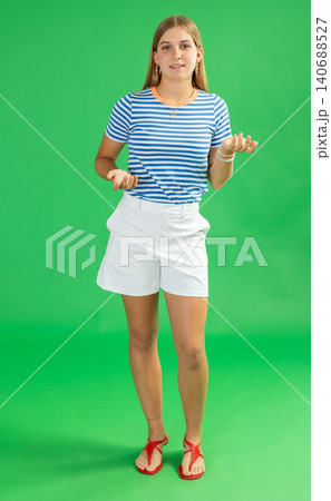 Teenage girl explaining or telling something in front of green screen 140688527