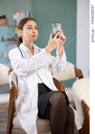 Young female student taking a photo of a lecture on mobile 140688697