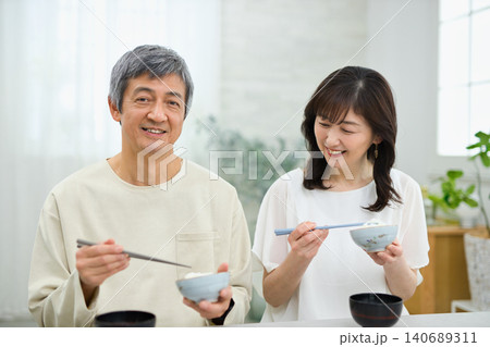 美味しそうに朝食を食べる60代の夫婦 美味しそうに朝食を食べる60代の夫婦 140689311