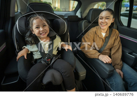 happy mother take care her preschool girl in car seat. play and talking with child happy mother take care her preschool girl in car seat. play and talking with child 140689776