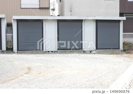 屋外の敷地に並ぶグレーのシャッター付きコンテナ型トランクルーム 140690876