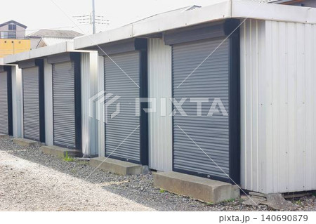 屋外の敷地に並ぶグレーのシャッター付きコンテナ型トランクルーム 屋外の敷地に並ぶグレーのシャッター付きコンテナ型トランクルーム 140690879