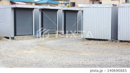 屋外の敷地に並ぶグレーのシャッター付きコンテナ型トランクルーム 屋外の敷地に並ぶグレーのシャッター付きコンテナ型トランクルーム 140690883