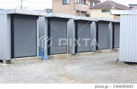 屋外の敷地に並ぶグレーのシャッター付きコンテナ型トランクルーム 屋外の敷地に並ぶグレーのシャッター付きコンテナ型トランクルーム 140690885