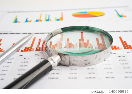 Magnifying glass on spreadsheet and graph paper. Financial data economy, Business. Magnifying glass on spreadsheet and graph paper. Financial data economy, Business. 140690955