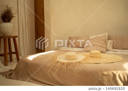 Stylish bedroom featuring a neutral palette and decorative hats 140692820