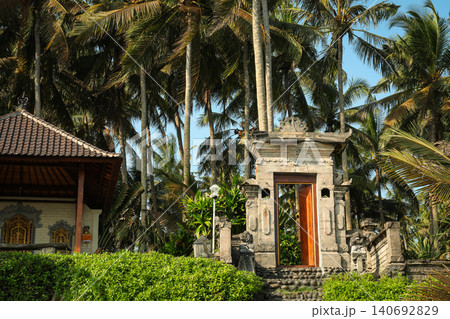 Visitors approach a temple entrance framed by palm trees Visitors approach a temple entrance framed by palm trees 140692829