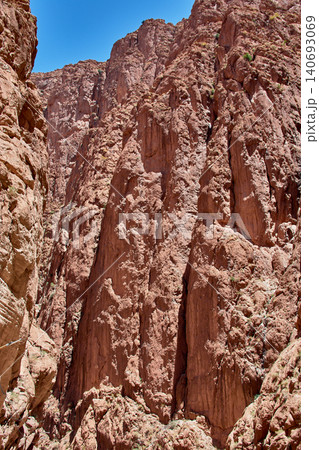 Large reddish limestone formations create a narrow natural canyon in the Todra Gorge. Large reddish limestone formations create a narrow natural canyon in the Todra Gorge. 140693069