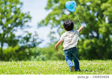 虫取り網を持って草原を駆ける男の子の後ろ姿 虫取り網を持って草原を駆ける男の子の後ろ姿 140693608