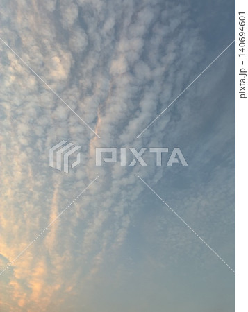 夕焼けに染まるうろこ雲と青空の背景素材【たて】 夕焼けに染まるうろこ雲と青空の背景素材【たて】 140694601