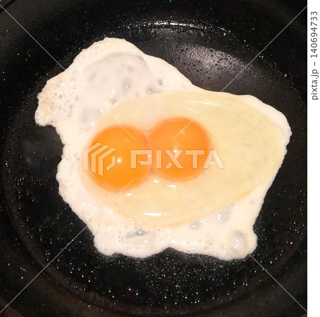 朝食作りの偶然の幸運(2つの黄身が入った目玉焼き) 朝食作りの偶然の幸運(2つの黄身が入った目玉焼き) 140694733