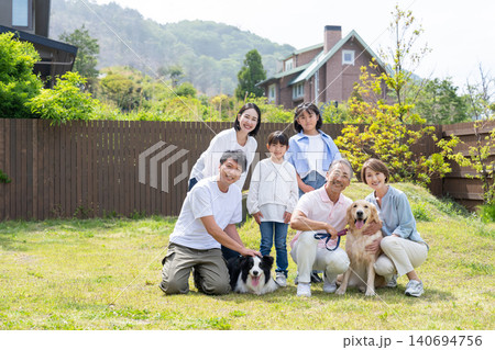 庭で愛犬2匹と笑顔で並ぶ3世代家族 庭で愛犬2匹と笑顔で並ぶ3世代家族 140694756