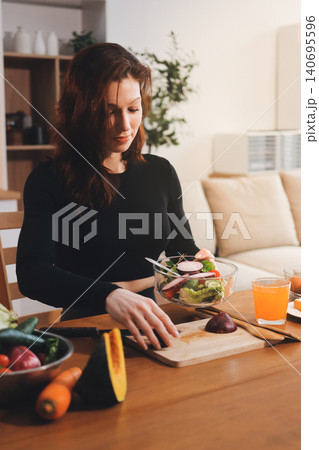Woman preparing green smoothie in bright kitchen with fresh fruits and vegetables, healthy eating lifestyle moment in natural daylight Woman preparing green smoothie in bright kitchen with fresh fruits and vegetables, healthy eating lifestyle moment in natural daylight 140695596