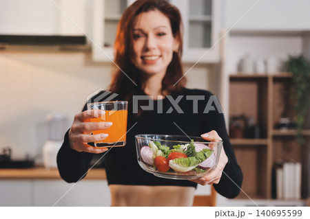 Woman preparing green smoothie in bright kitchen with fresh fruits and vegetables, healthy eating lifestyle moment in natural daylight Woman preparing green smoothie in bright kitchen with fresh fruits and vegetables, healthy eating lifestyle moment in natural daylight 140695599
