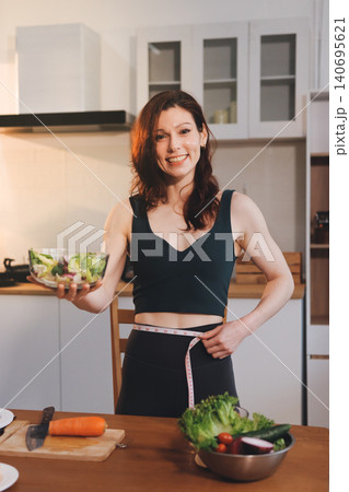 Woman preparing green smoothie in bright kitchen with fresh fruits and vegetables, healthy eating lifestyle moment in natural daylight Woman preparing green smoothie in bright kitchen with fresh fruits and vegetables, healthy eating lifestyle moment in natural daylight 140695621