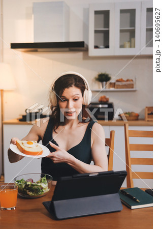 Woman preparing green smoothie in bright kitchen with fresh fruits and vegetables, healthy eating lifestyle moment in natural daylight Woman preparing green smoothie in bright kitchen with fresh fruits and vegetables, healthy eating lifestyle moment in natural daylight 140695627