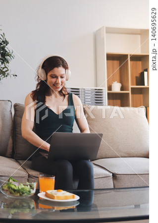 Woman preparing green smoothie in bright kitchen with fresh fruits and vegetables, healthy eating lifestyle moment in natural daylight Woman preparing green smoothie in bright kitchen with fresh fruits and vegetables, healthy eating lifestyle moment in natural daylight 140695629