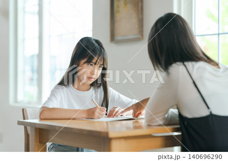 勉強を教える母親と嫌がる子ども 勉強を教える母親と嫌がる子ども 140696290