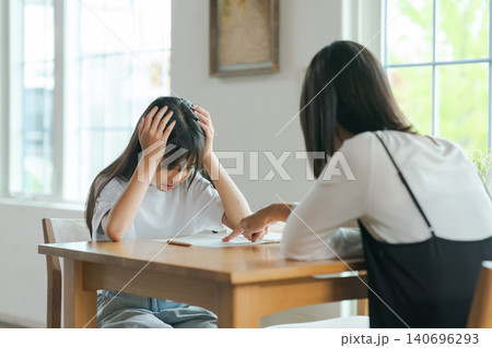 勉強を教える母親と嫌がる子ども 勉強を教える母親と嫌がる子ども 140696293