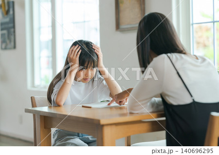 勉強を教える母親と嫌がる子ども 勉強を教える母親と嫌がる子ども 140696295
